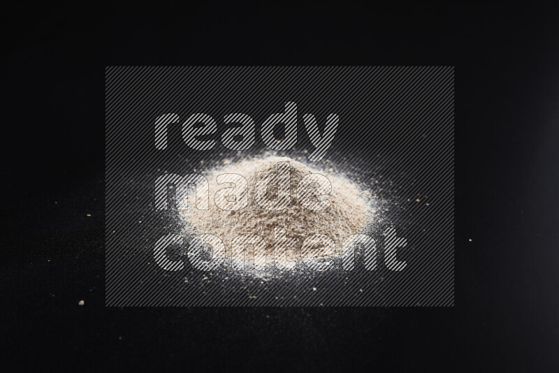 A bunch of onion powder on black background