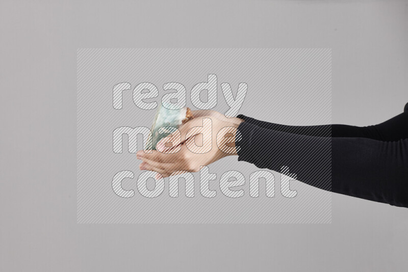 A woman in black abaya holding different pottery essentials in different positions