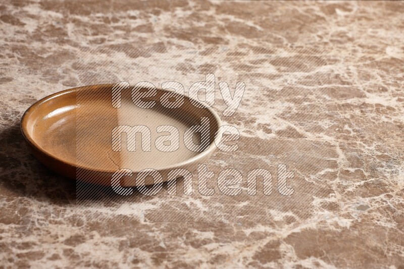 A multicolored pottery oven plate on beige marble background