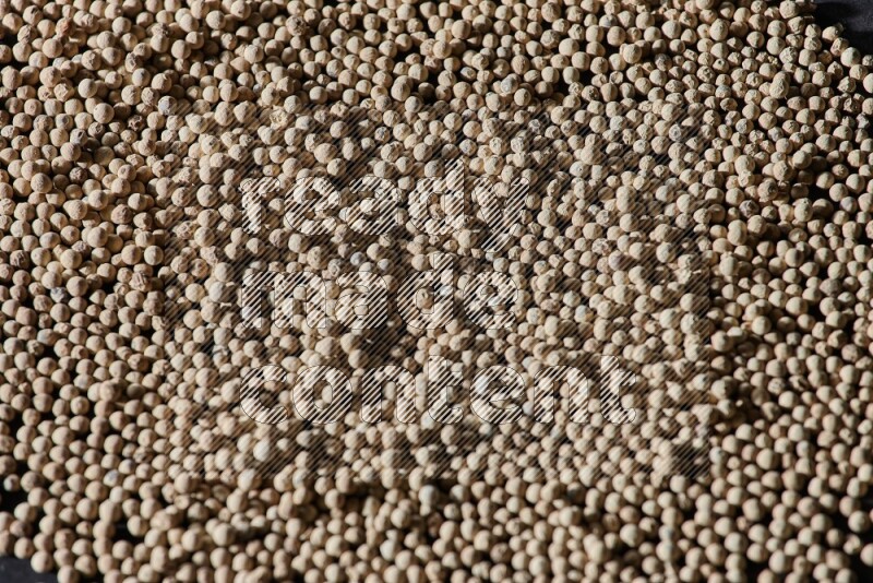 White pepper beads on black flooring