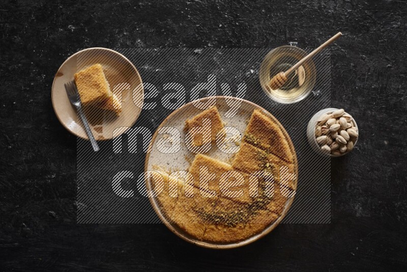 Konafa with nuts and honey in a dark setup