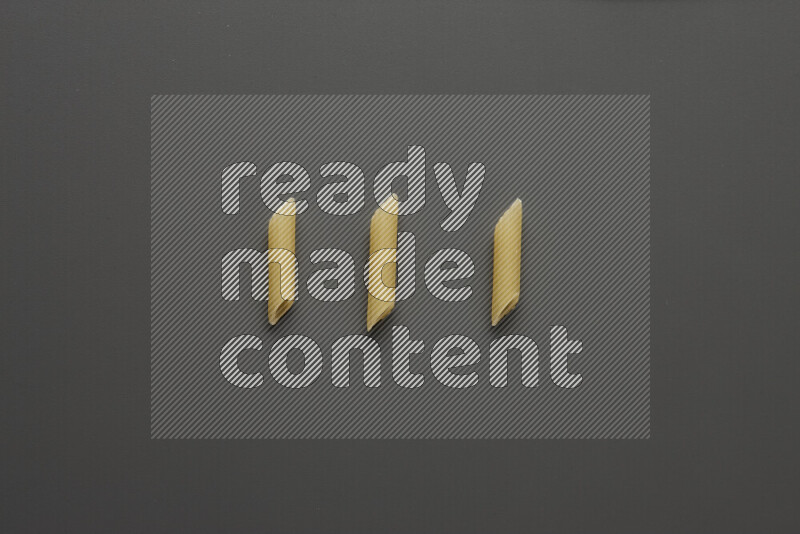Mini penne pasta on grey background