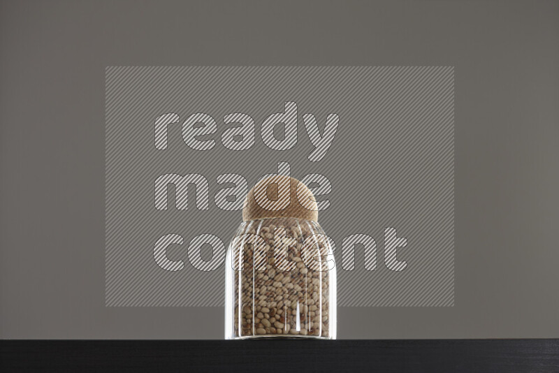 Black-eyed peas in a glass jar on black background