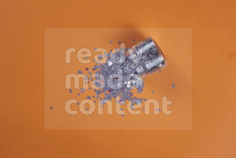 A purple collection of sewing and tailoring tools arranged on a orange background