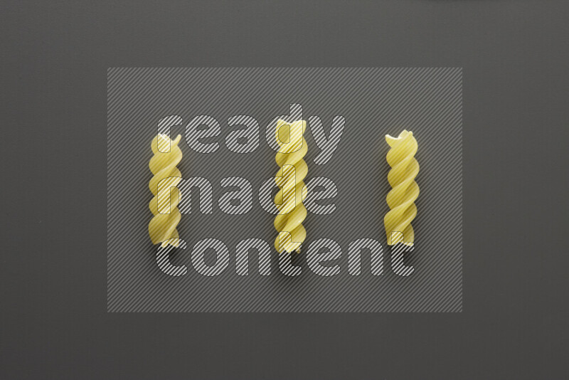 Fusilli pasta on grey background