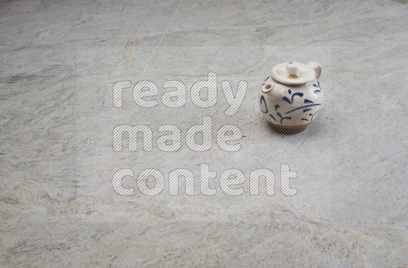 A pottery teapot on grey marble background