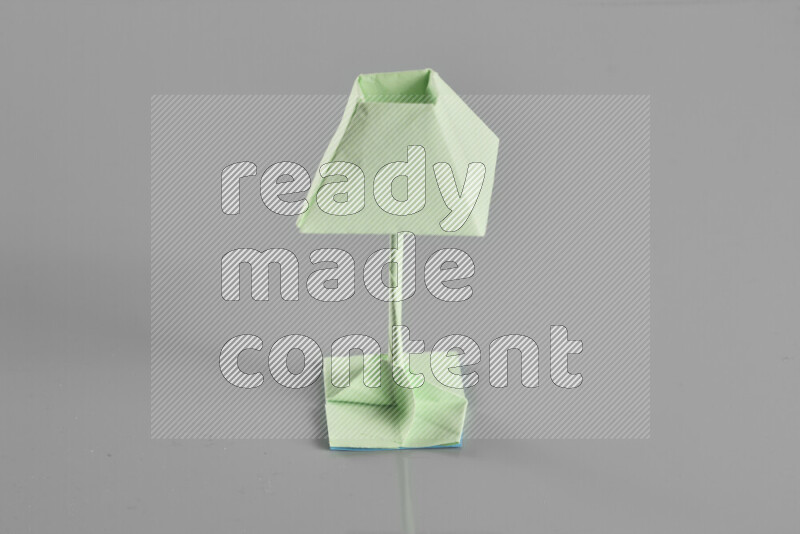 Origami floor lamp on grey background