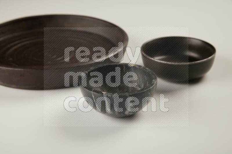 black pottery plate and black bowls on white background