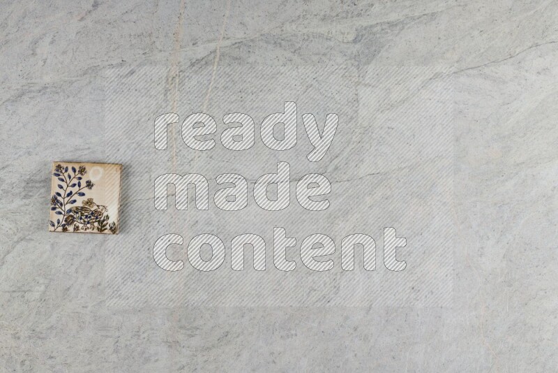 A decorative pottery coaster on grey marble background