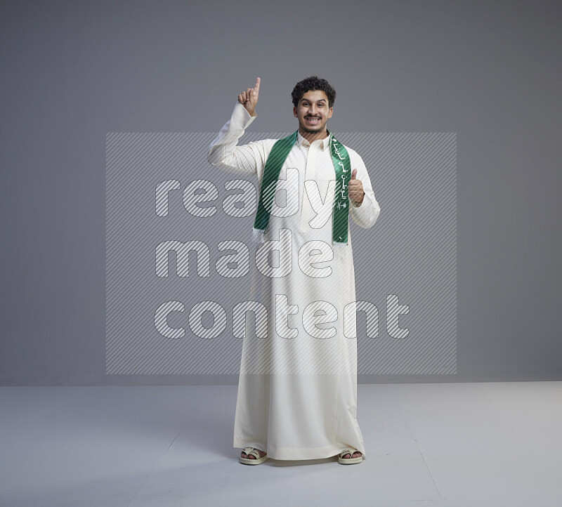 رجل سعودي يرتدي ثوب ابيض و شال يتفاعل مع الكاميرا