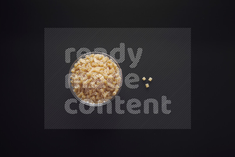 Small rings pasta in a glass bowl on black background