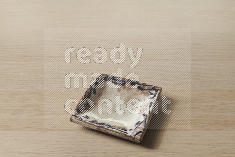 A decorative pottery plate on light wooden background
