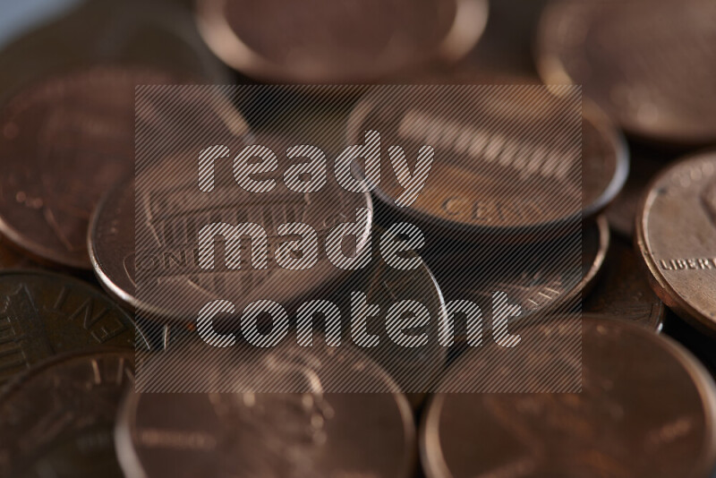 A close-up of scattered United States one cent coins on grey background