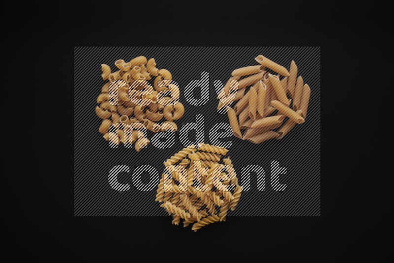 Different pasta types in bunches on black background