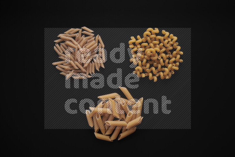 Different pasta types in bunches on black background