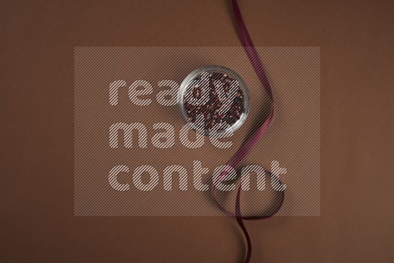 A red collection of sewing and tailoring tools arranged on a brown background