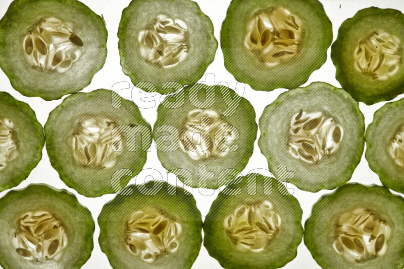 Cucumber slices on illuminated white background