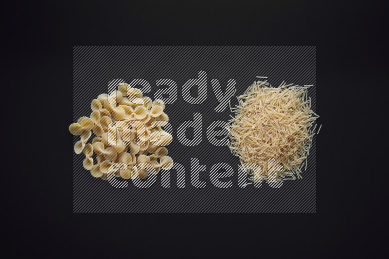 Different pasta types in bunches on black background
