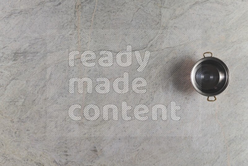 A small copper pot on grey marble background