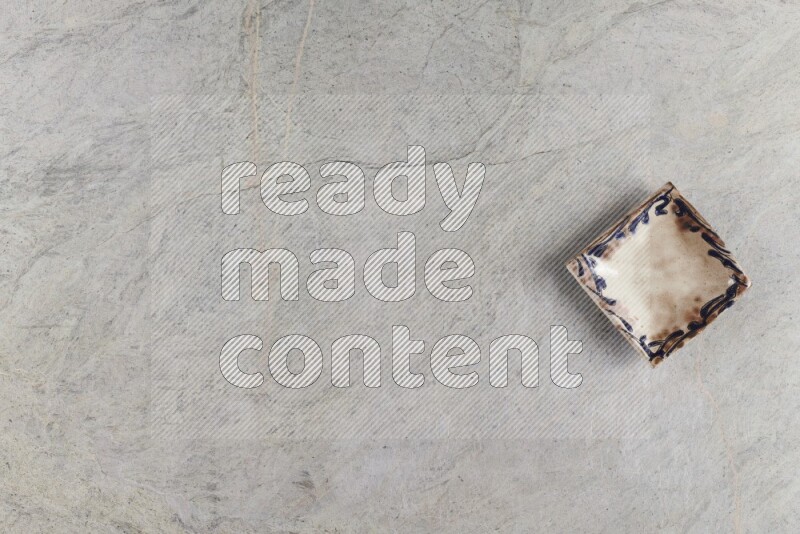 A decorative pottery plate on grey marble background