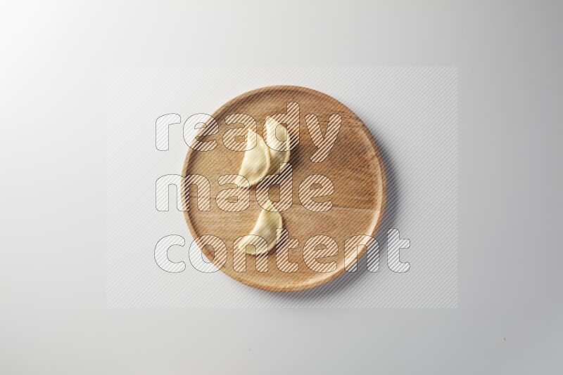 Three Sambosas on a wooden round plate on a white background