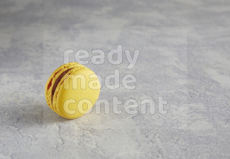 45º Shot of Yellow Lemon macaron on white  marble background