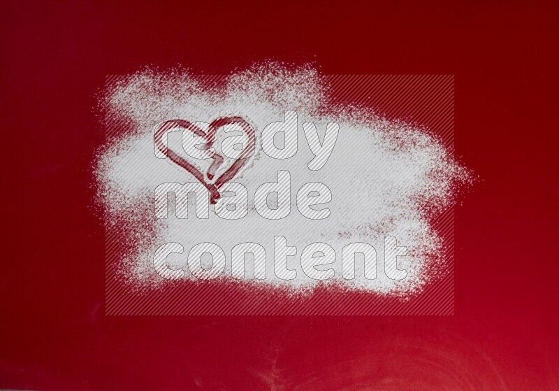 A heart drawn with powder on red background