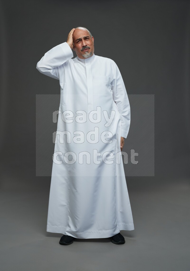 Saudi man without shomag Standing Interacting with the camera on gray background