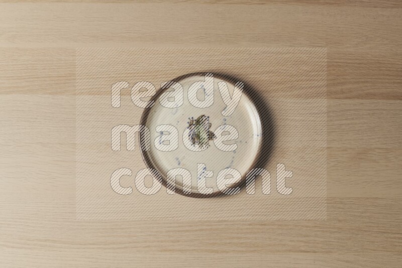 A decorative pottery plate on light wooden background