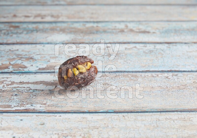pistachio stuffed madjoul date on a light blue wooden background