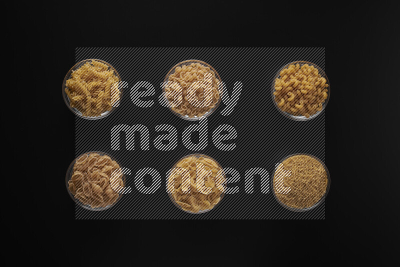 أنواع مختلفة من المعكرونة في أوعية زجاجية علي خلفية سوداء