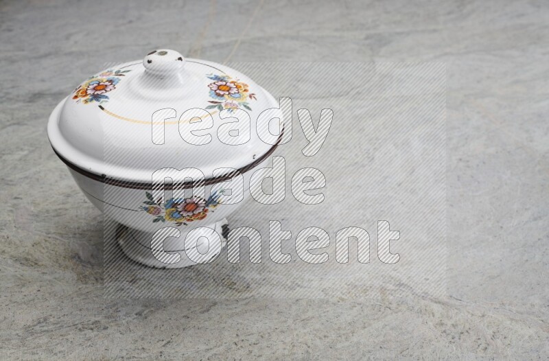 A vintage metal pot on grey marble background