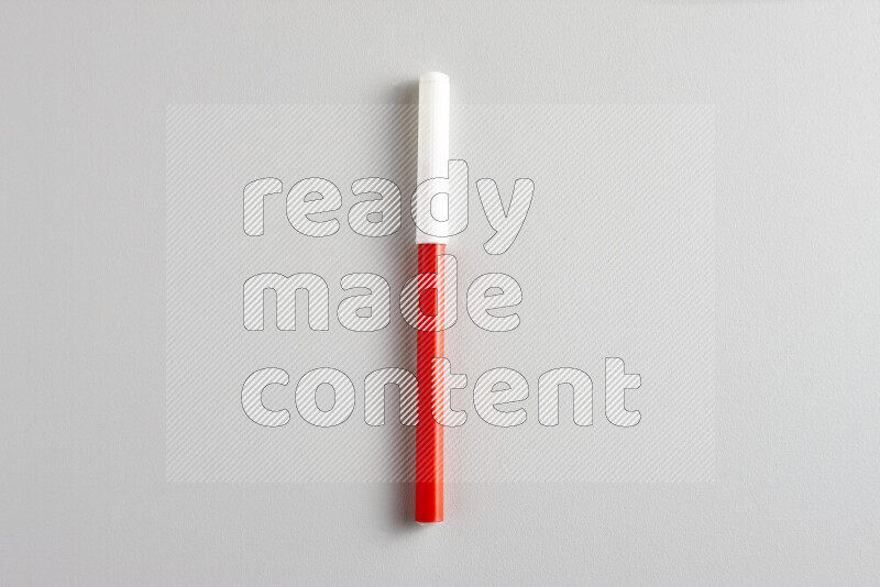 A close-up showing a single coloring pen with a cap on grey background