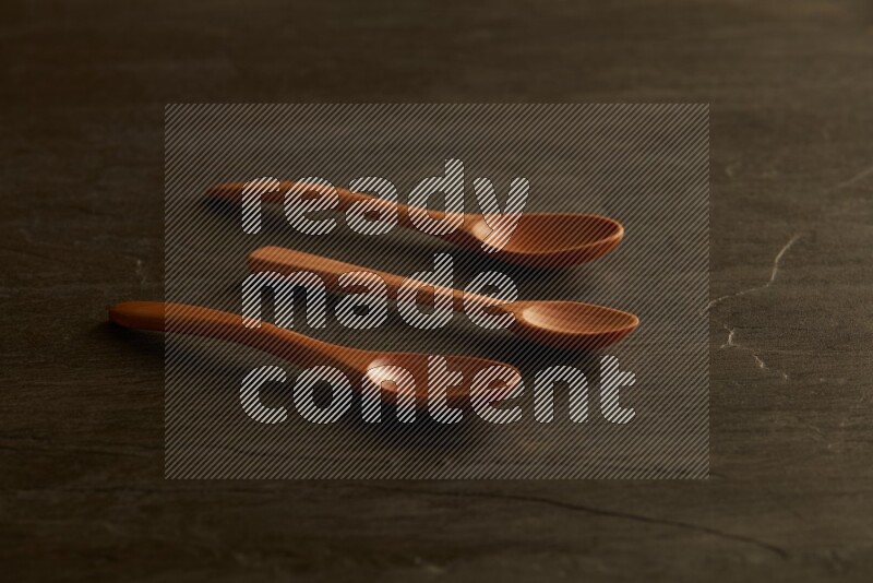 wooden spoon on black slate background