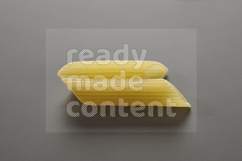 Penne pasta on grey background