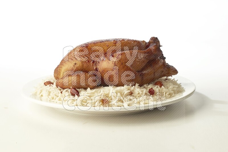 white  basmati Rice with  whole roasted chicken  on a white rounded plate direct on white background