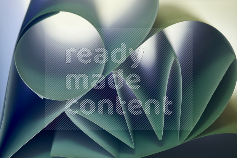 An artistic display of paper folds creating a harmonious blend of geometric shapes, highlighted by soft lighting in green tones