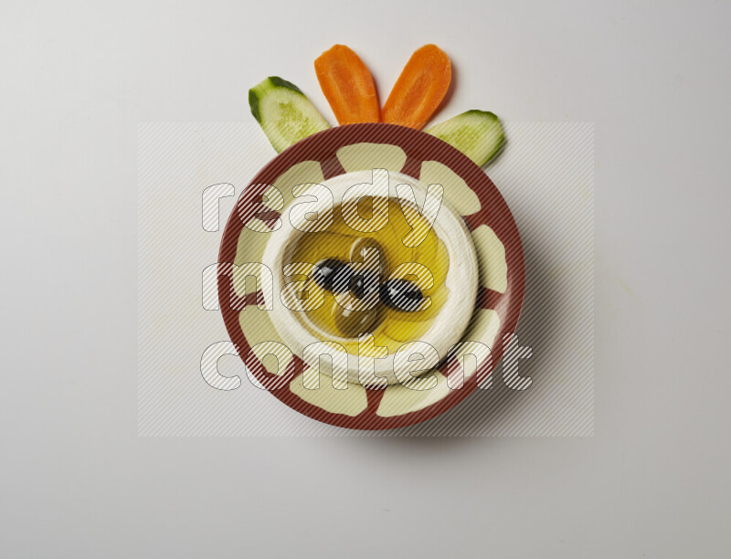Lebnah garnished with olives in a traditional plate on a white background