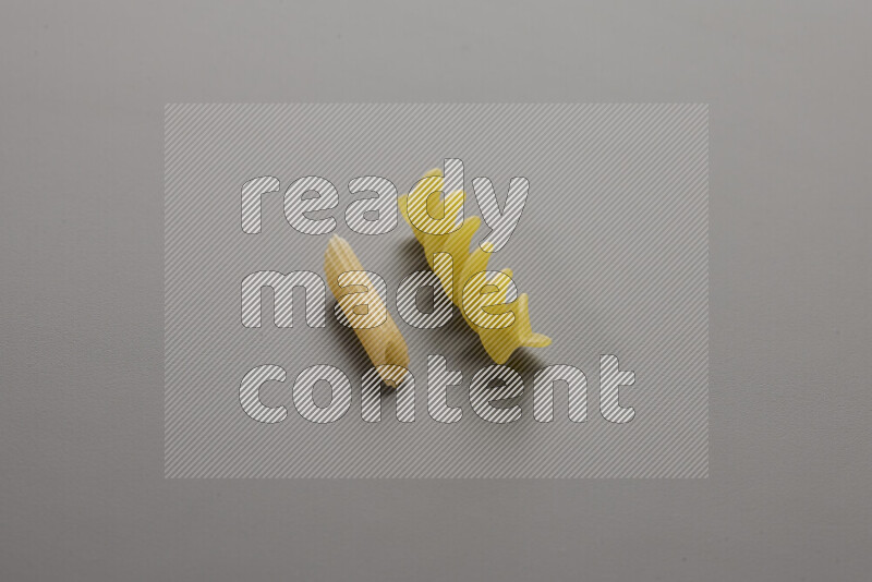 معكرونة فرن صغيرة مع أنواع أخري من المعكرونة علي خلفية رمادية