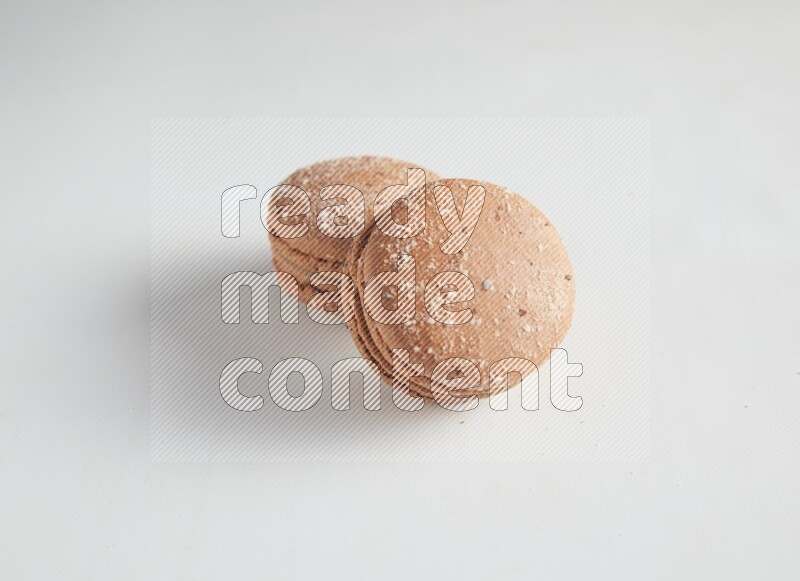 45º Shot of two Brown Hazelnuts macarons on white background