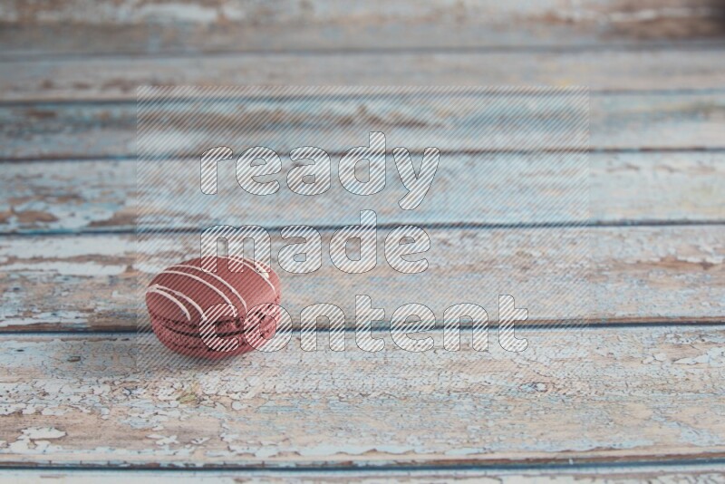 45º Shot of Red Poppy Flower macaron on light blue wooden background