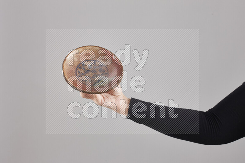 امرأة ترتدي عباءة سوداء تحمل أدوات فخارية مختلفة في أوضاع متعددة