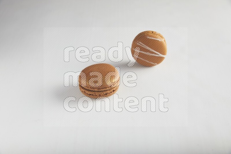 45º Shot of of two assorted Brown Irish Cream, and Brown Coffee macarons  on white background