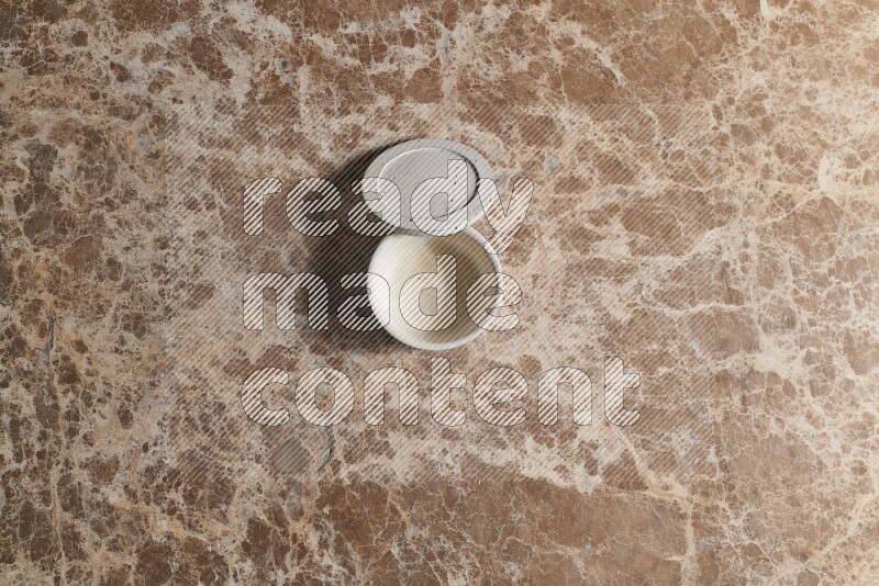 A pottery cup on beige marble background