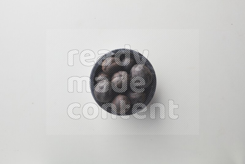 Top-view shot of dried lime (loomi) in a container on white background