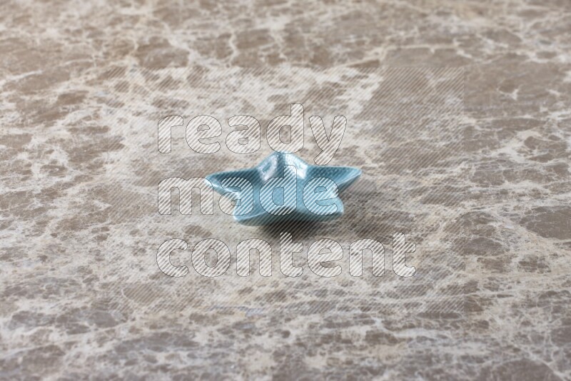 A colored pottery star plate on beige marble background