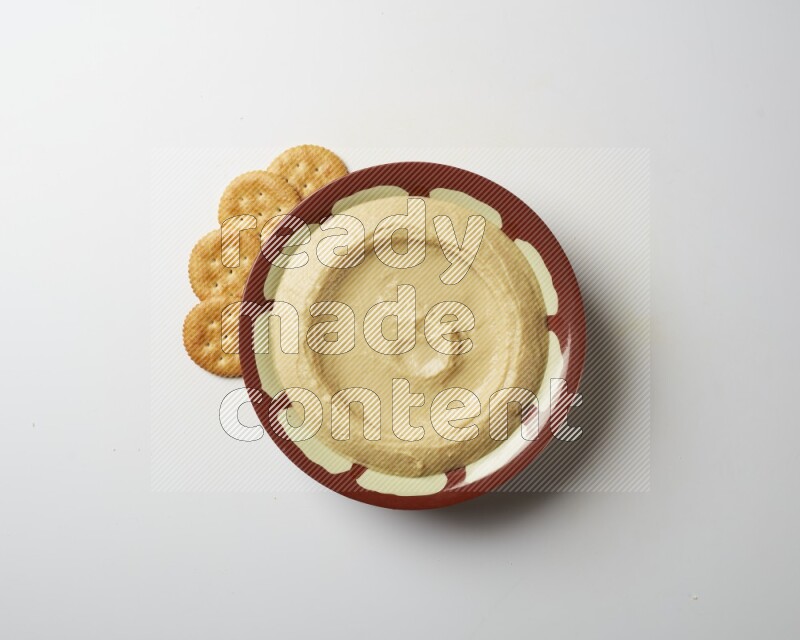 Plain hummus in a traditional plate on a white background