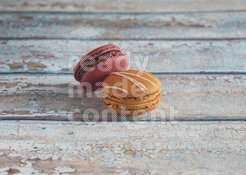 45º Shot of of two assorted Brown Irish Cream, and Red Cherry macarons  on light blue background