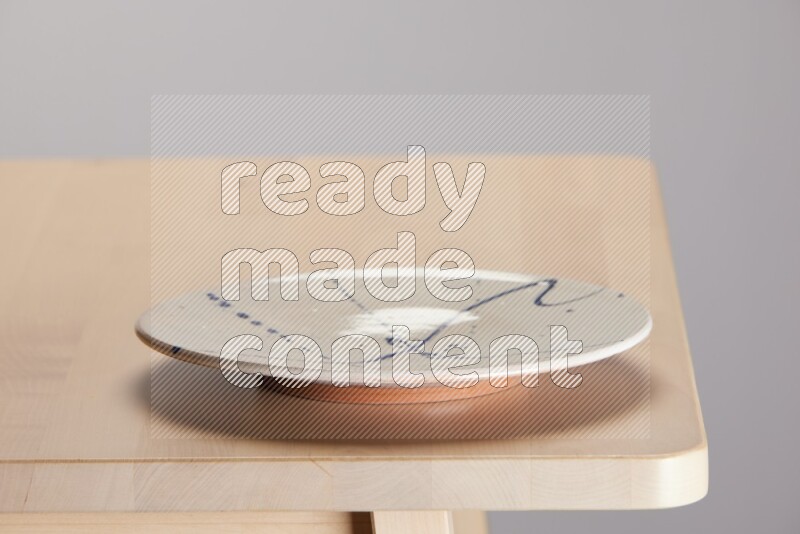 multi-colored pottery Plate on a wooden table edge