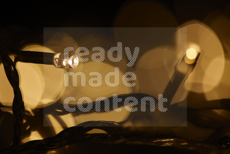 Light bulbs glowing against backdrop of golden bokeh